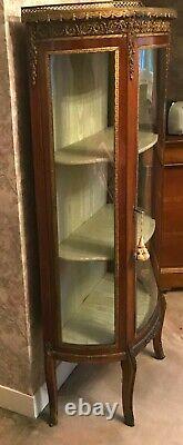 Vitrine en bois de placage garniture de laiton toutes faces vitrées. XX siècle